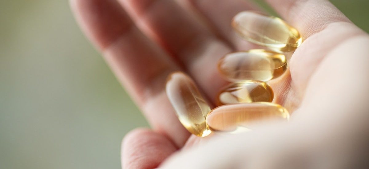 A person holding a handful of pills in their hand