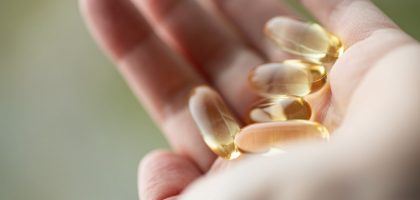 A person holding a handful of pills in their hand