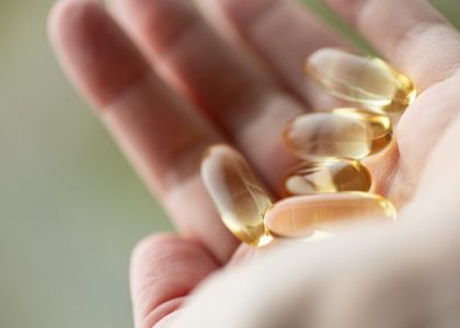 A person holding a handful of pills in their hand